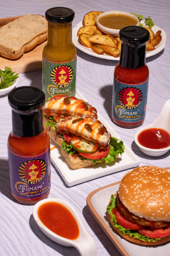 Assorted Fumami sweet and spicy fermented hot sauce bottles with food items on a table