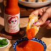 Dipping dumpling into a bowl of Fumami fermented hot sauce.