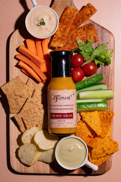 Fumami Creamy Salsa sauce bottle on a charcuterie board with chips, vegetables, and crackers